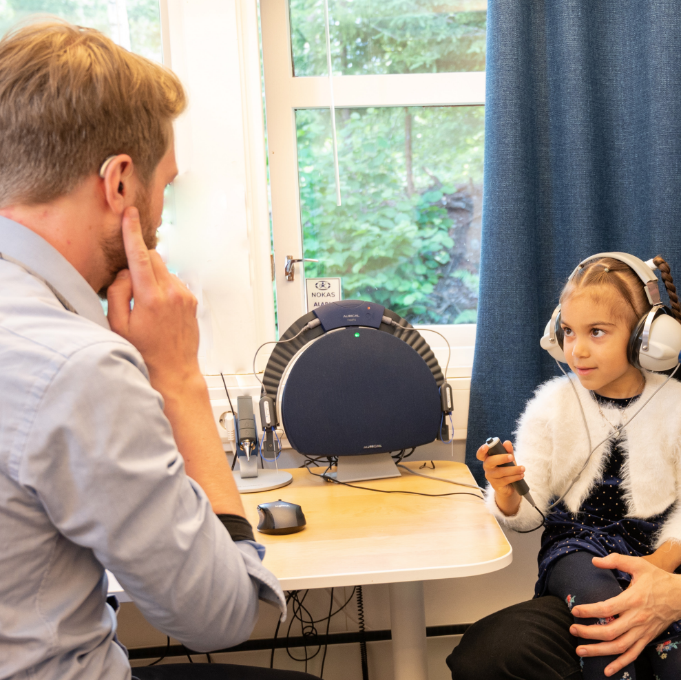En jente får testet hørsel hos audiograf