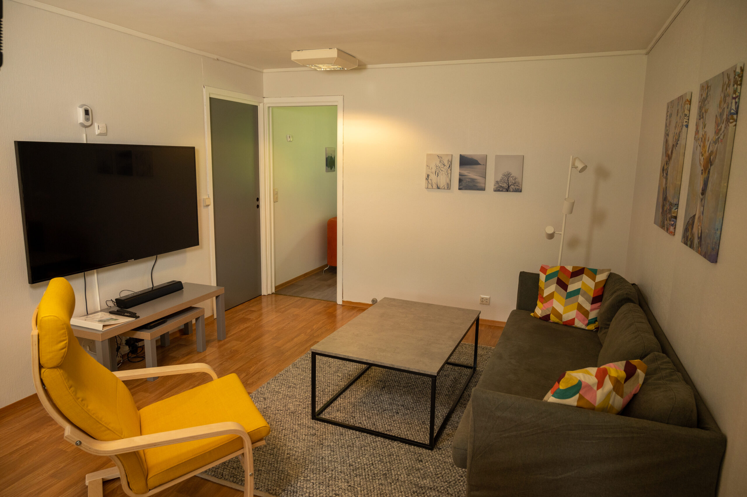 Tuoli, sohva, pöytä ja TV huoneistossa 15