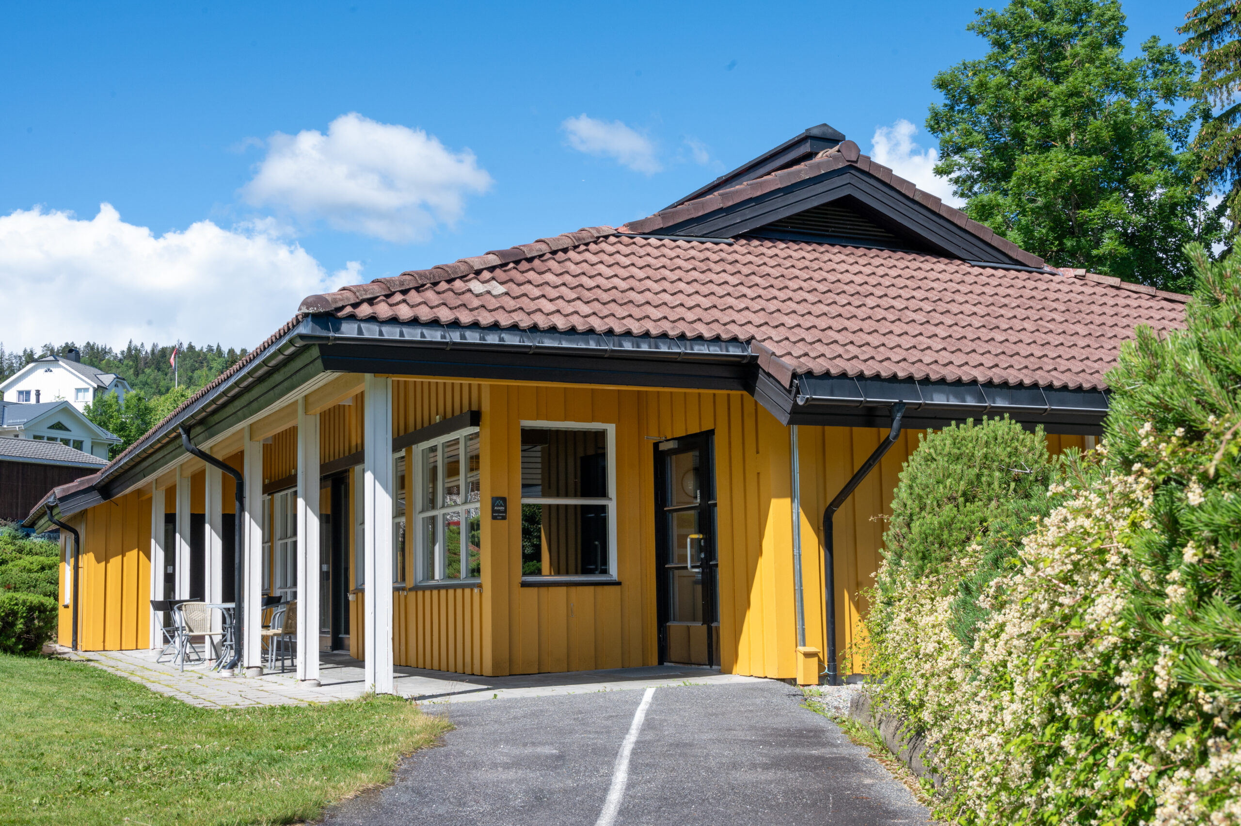 Ragnhild Kaatan talo osoitteessa Eikholt. Matala, pitkulainen, yksikerroksinen talo, jonka sisäänkäynti on opastettu. Pylväät, joiden alla on katos, jonka alla voi istua.
