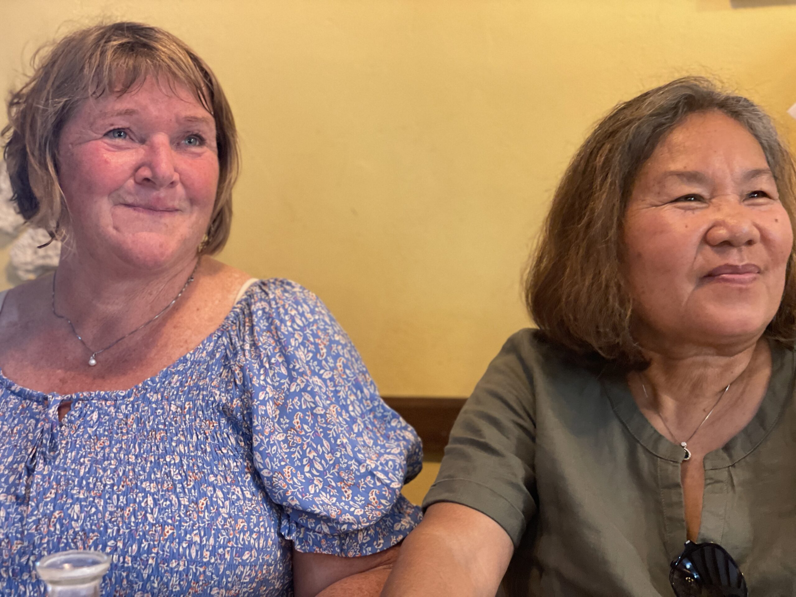 Turid and Ruchipa sit next to each other and smile