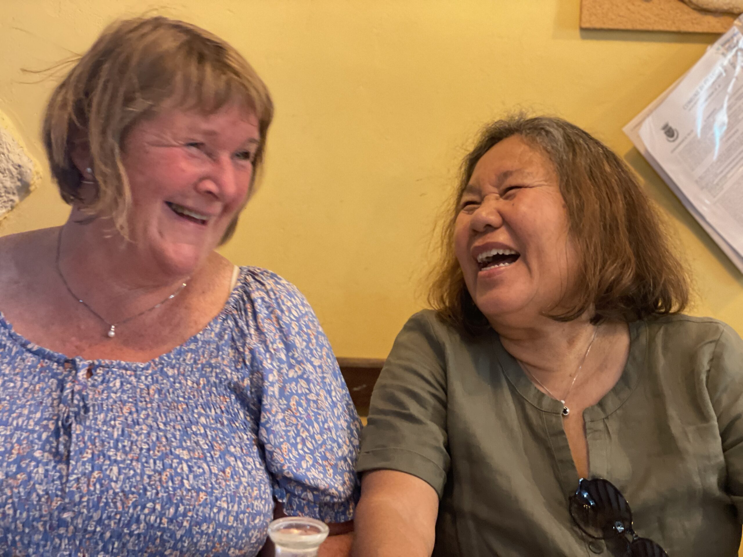 Turid and Ruchipa sit next to each other and laugh