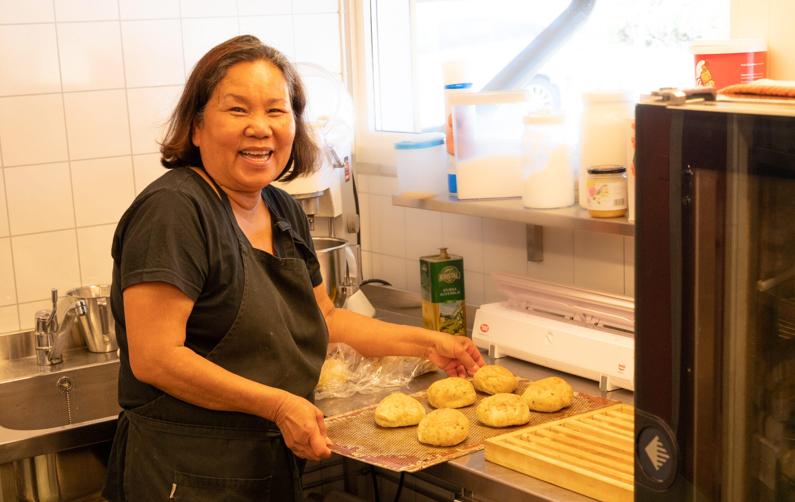 Ruchipa is in the kitchen with rolls on a tray