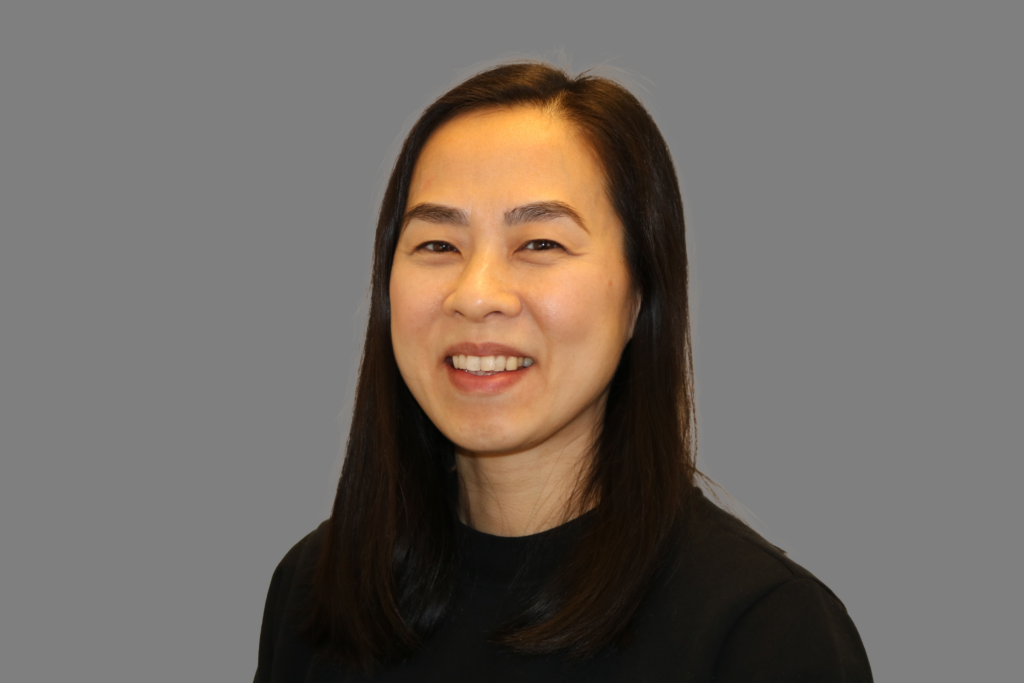 Portrett av Thanh. Hun har langt sort hår , mørke øyebryn og brune øyne. Hun har på en sort genser.