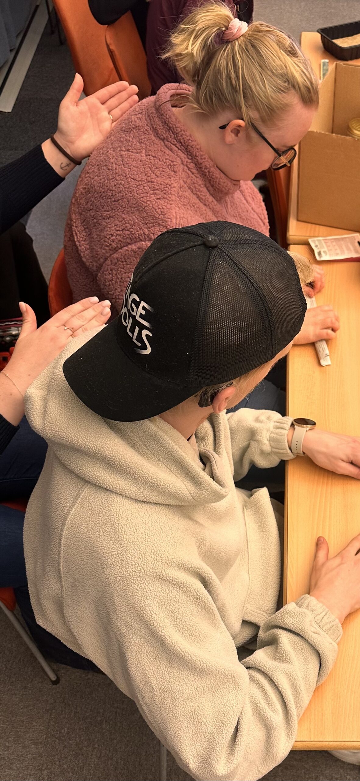To personer sidder ved et bord og modtager haptiske signaler på ryggen